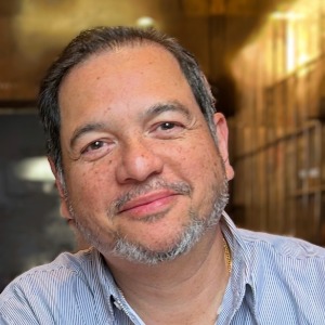 Smiling person in casual shirt indoors.