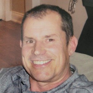 Smiling man sitting indoors, casual attire
