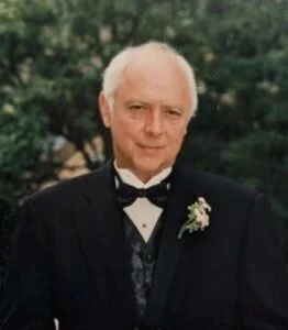 Elderly man in suit with boutonniere.
