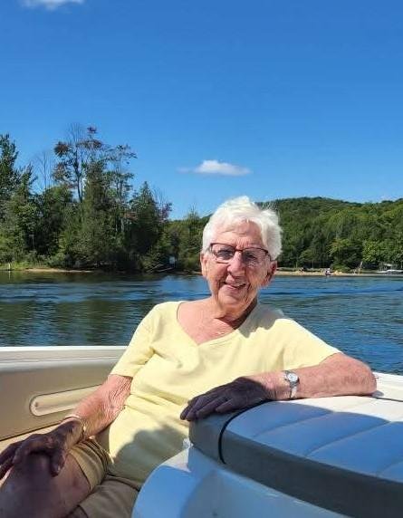 Woman enjoying boat ride on sunny lake day.