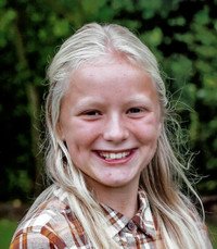 Smiling child outdoors with plaid shirt
