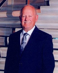 Smiling man in suit with bookshelf background