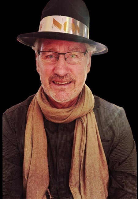 Smiling man in hat and scarf with glasses.