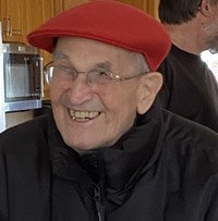 Smiling elderly man in red hat indoors