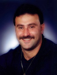 Smiling man with mustache and dark hair