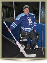Senior hockey goalie in uniform on ice rink