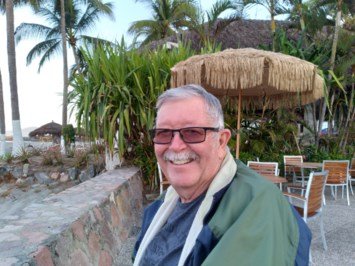 Smiling person outdoors near tropical plants