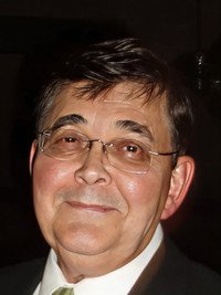 Smiling person wearing glasses and a suit