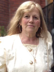 Woman in white jacket with hoop earrings
