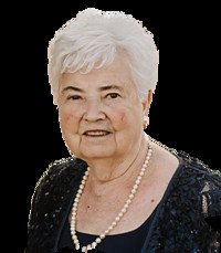 Elderly woman wearing pearls and a dark outfit.