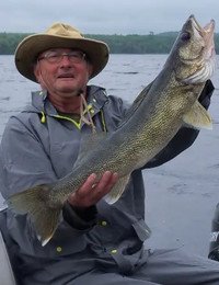 Person holding large fish on a lake.