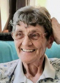 Smiling elderly woman with glasses and gray hair.