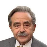 Elderly man in a suit with a mustache.