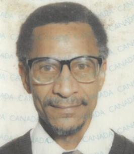 Man with glasses and tie smiling slightly.