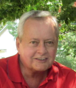 Smiling man in red shirt under tree
