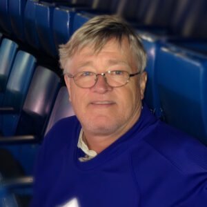 Person sitting in blue stadium seats
