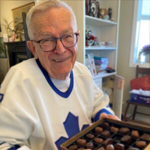 Smiling man holding a box of chocolates.