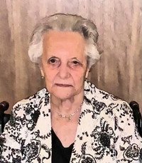 Elderly woman in floral jacket, neutral expression