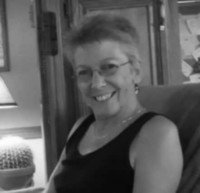Smiling person sitting indoors, black and white photo.