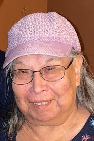 Smiling person wearing a pink cap indoors.