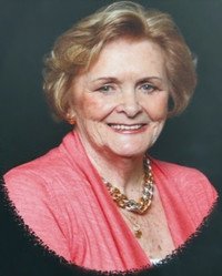 Smiling woman in pink outfit and necklace