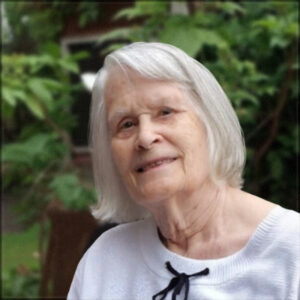 Elderly woman smiling outdoors in garden