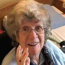 Smiling elderly woman with glasses and curly hair.