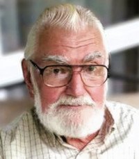 Elderly man with glasses and white beard.