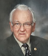 Elderly man in suit and tie, glasses on.
