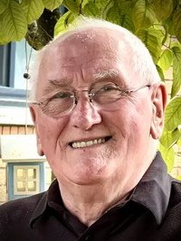 Smiling man outdoors with glasses and white hair