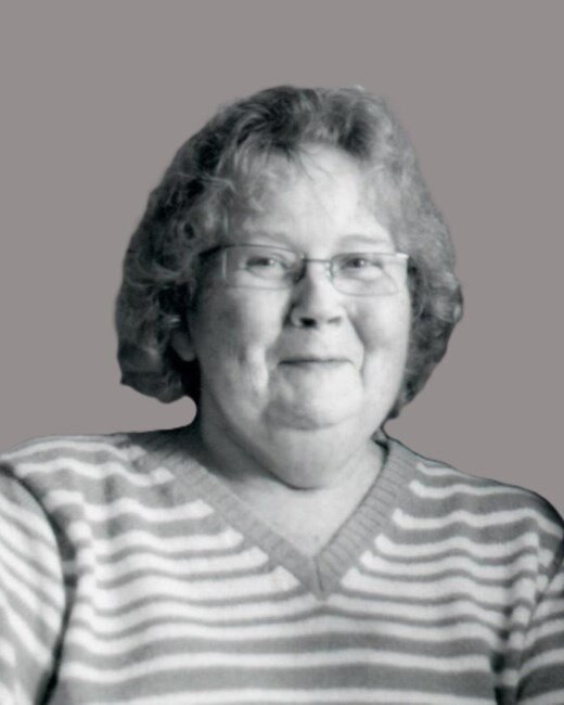 Smiling person in striped sweater, grayscale image.