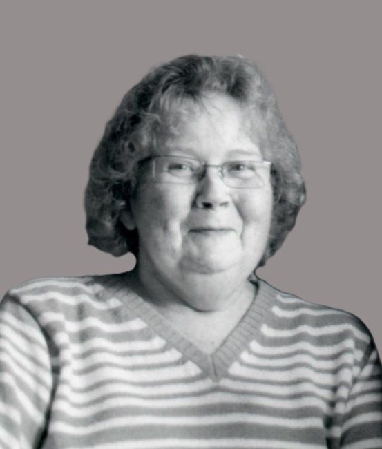 Smiling person in striped sweater, grayscale image.