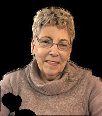 Elderly woman smiling in warm sweater.