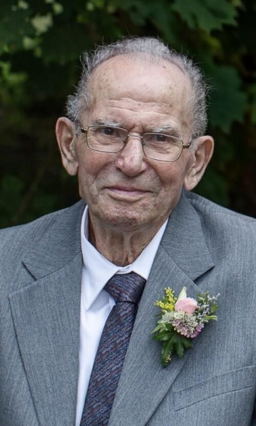 Elderly man in gray suit with boutonniere