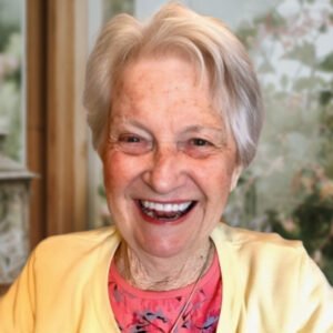 Smiling elderly woman in a bright yellow sweater.
