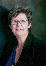 Smiling woman with glasses and short hair.