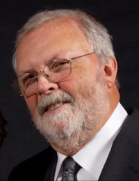 Smiling man with glasses and beard in suit