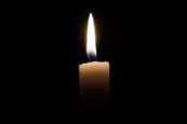 Lit candle in darkness