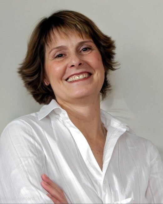 Smiling person wearing white shirt.