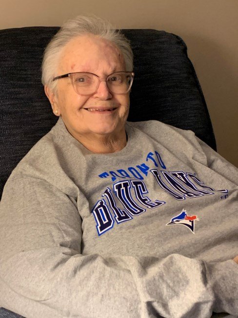 Smiling person wearing a Toronto Blue Jays sweatshirt.