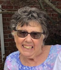 Smiling elderly woman outdoors with sunglasses.