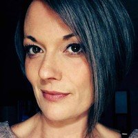 Person with short hair and a slight smile.