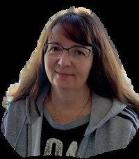 Woman wearing glasses and casual hoodie, smiling.