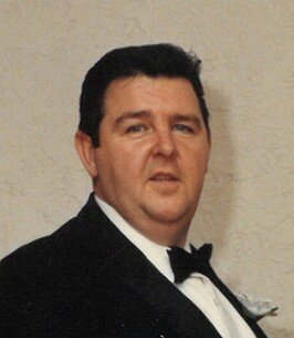 Man in a black tuxedo and bow tie.