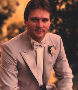 Man in formal gray suit with bow tie.