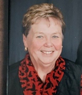 Smiling person with short hair and red scarf