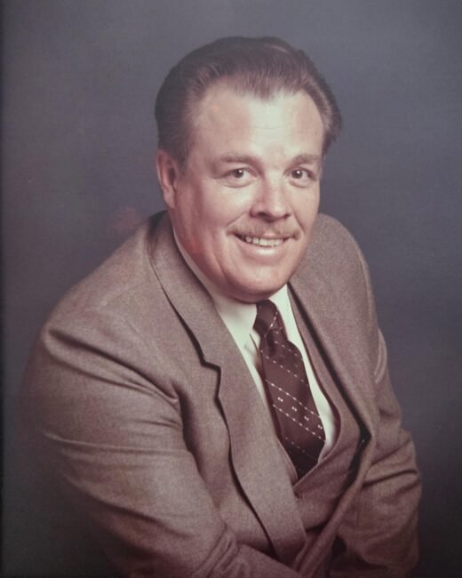 Man in suit smiling in professional portrait.