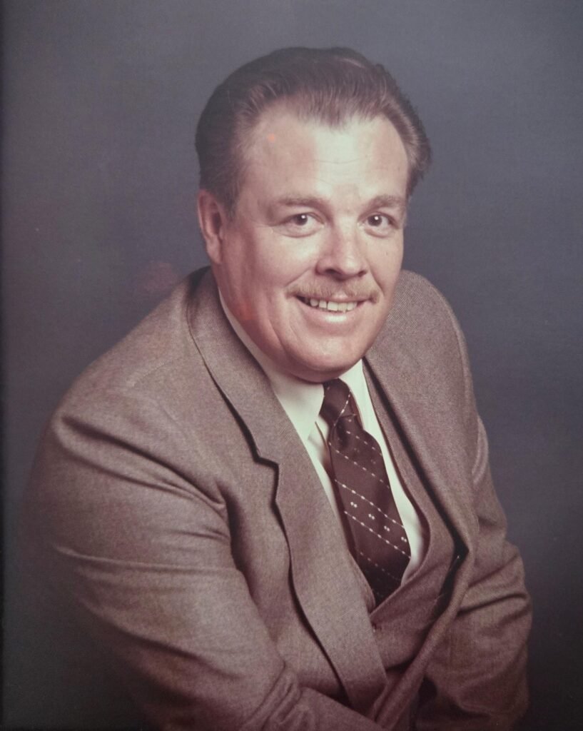 Man in suit smiling in professional portrait.