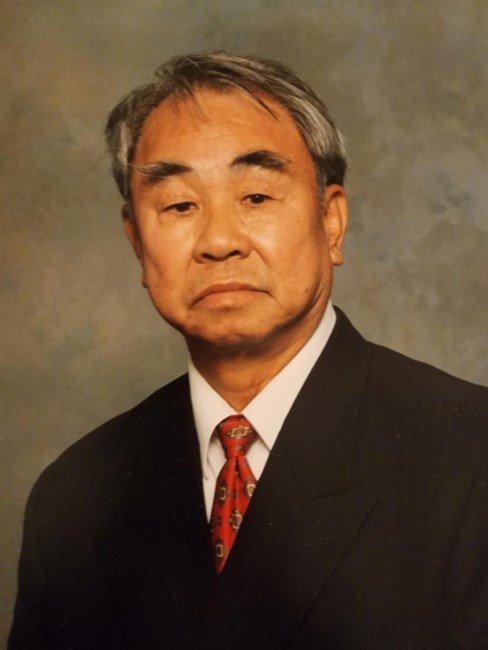 Elderly man in a suit, neutral expression.