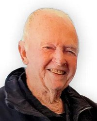 Elderly man smiling in a jacket.